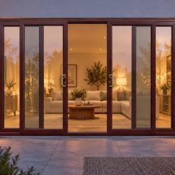 Rosewood uPVC 4 pane sliding patio door lit up in the evening