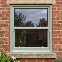 Agate Grey uPVC sliding sash window on a red brick house