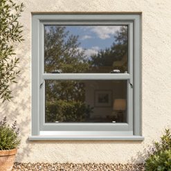 Agate Grey uPVC sliding sash window on a rendered cottage
