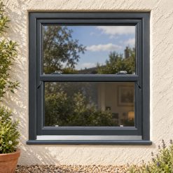 Anthracite Grey uPVC sliding sash window on a rendered cottage
