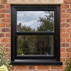 Black/Brown uPVC sliding sash window on a red brick house