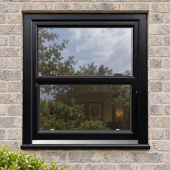 Black/Brown uPVC sliding sash window on a modern brick house