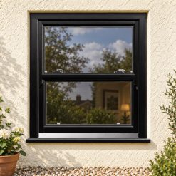 Black/Brown uPVC sliding sash window on a rendered cottage