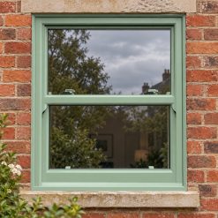 Chartwell Green uPVC sliding sash window on a red brick house