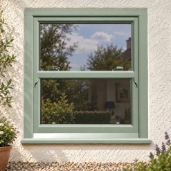 Chartwell Green uPVC sliding sash window on a rendered cottage