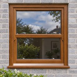 Golden Oak uPVC sliding sash window on a modern brick house