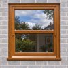 Golden Oak uPVC sliding sash window fitted in a brick house