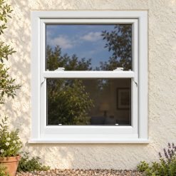 White uPVC sliding sash window on a rendered cottage