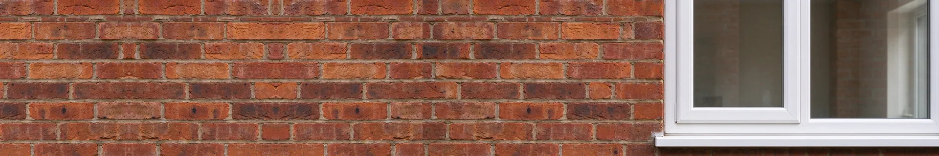 White uPVC casement window in a red brick wall