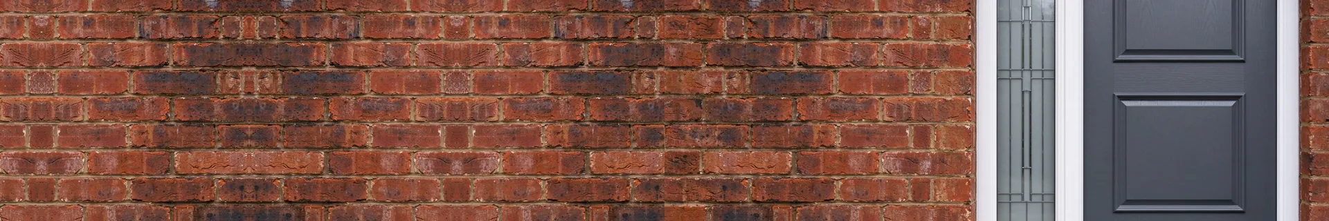 Grey composite front door in a red brick wall