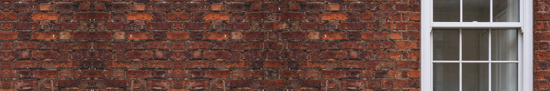 White uPVC sliding sash window in a red brick wall