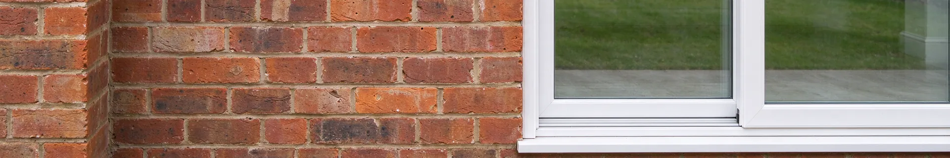 White uPVC sliding patio door in a red brick wall
